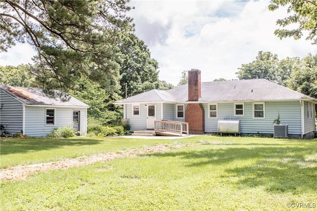 Rear view of property featuring oil tank, a chimney, and a lawn | Image 4