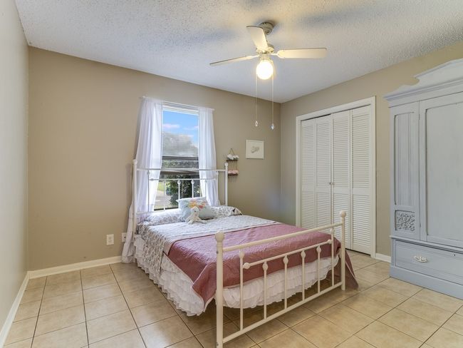 Bedroom featuring light tile patterned floors, ceiling fan, and a textured ceiling | Image 17