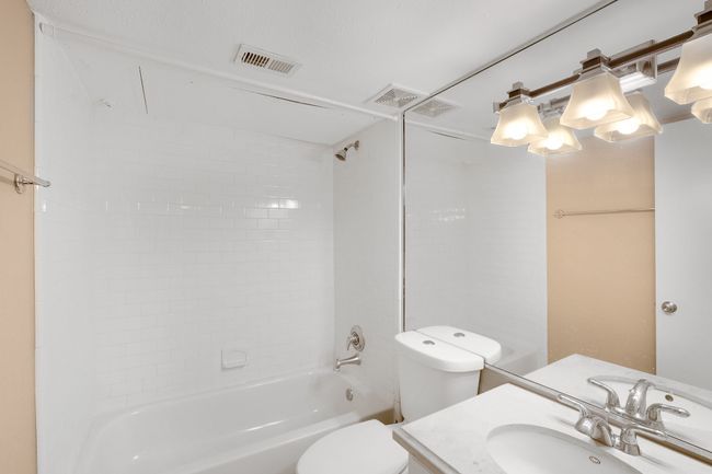 Bathroom featuring toilet, vanity, and shower / bath combination | Image 13