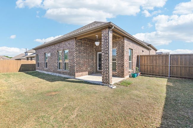 Back of property featuring a yard, brick siding, a fenced backyard, and a patio area | Image 31