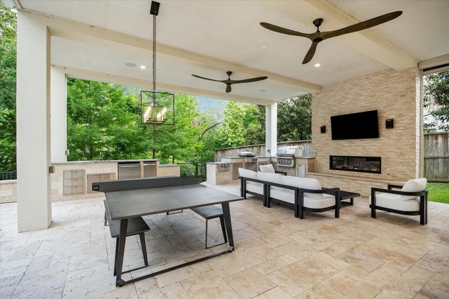 Indulge in outdoor luxury at with this exquisite covered patio. Featuring a cozy fireplace and a state-of-the-art stainless steel grill with ample counter space, this space is perfect for entertaining. | Image 4