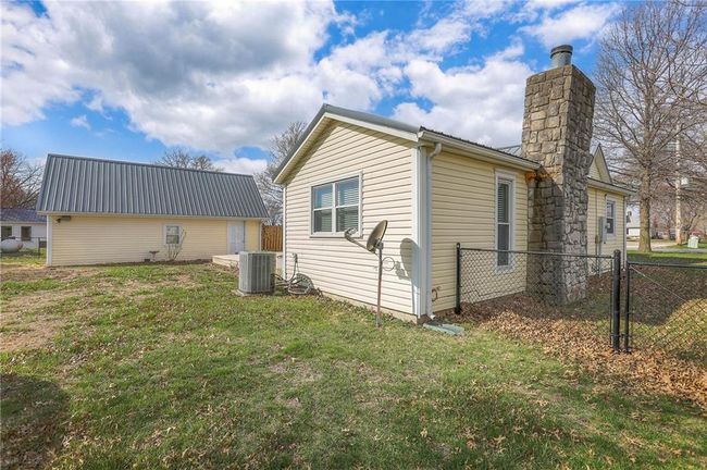 View of side of home with a gate, fence, central AC, and a yard | Image 10