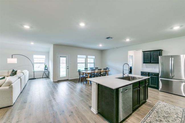Kitchen featuring stainless steel appliances, sink, light wood-type flooring, and a kitchen island with sink | Image 4