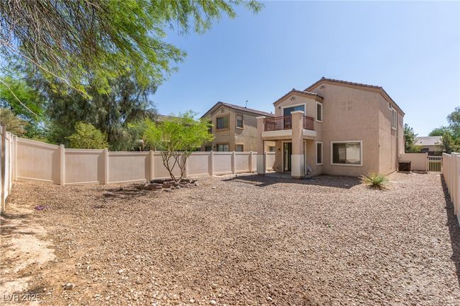 Rear view of property with a balcony, a fenced backyard, and stucco siding | Image 15