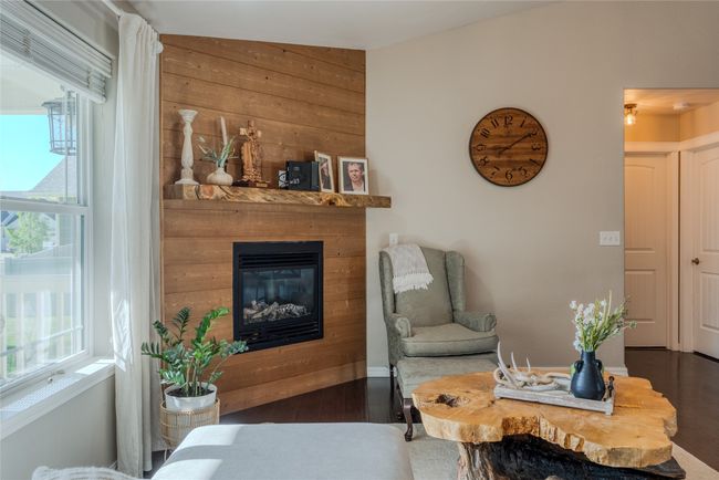 Living room featuring wood finished floors, a glass covered fireplace, and wooden walls | Image 9
