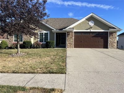 Ranch-style house with a front yard and a garage | Image 1