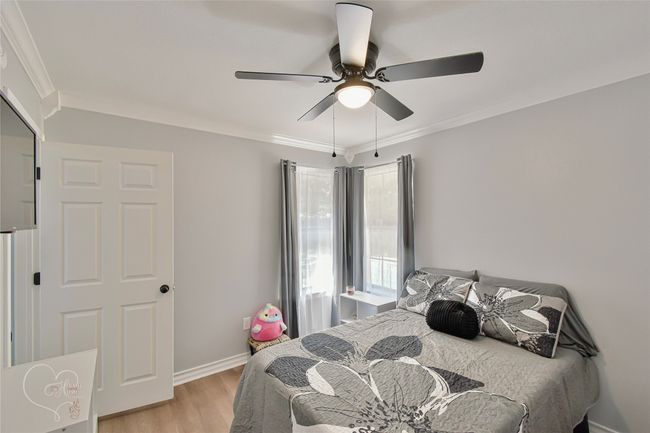 Bedroom featuring light wood-type flooring, ornamental molding, and a ceiling fan | Image 15