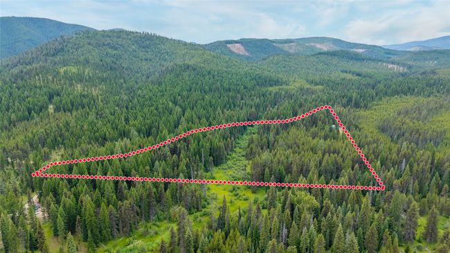 Aerial view of property and surrounding area featuring a mountainous background and property parcel outlined | Image 8
