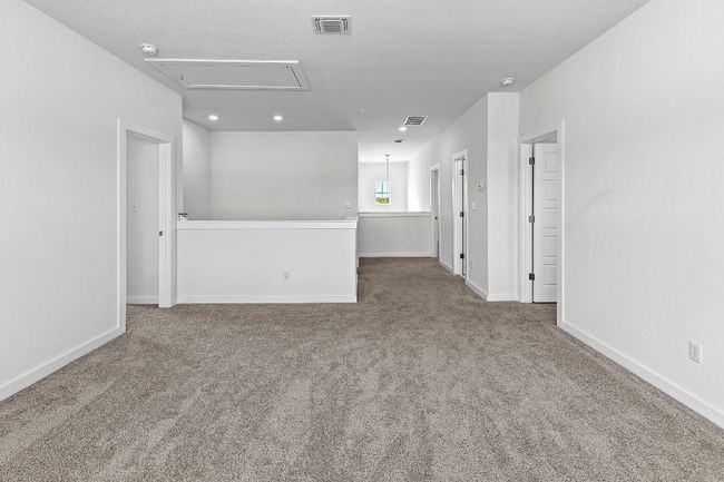 Carpeted empty room with attic access, baseboards, recessed lighting, and a smoke detector | Image 28
