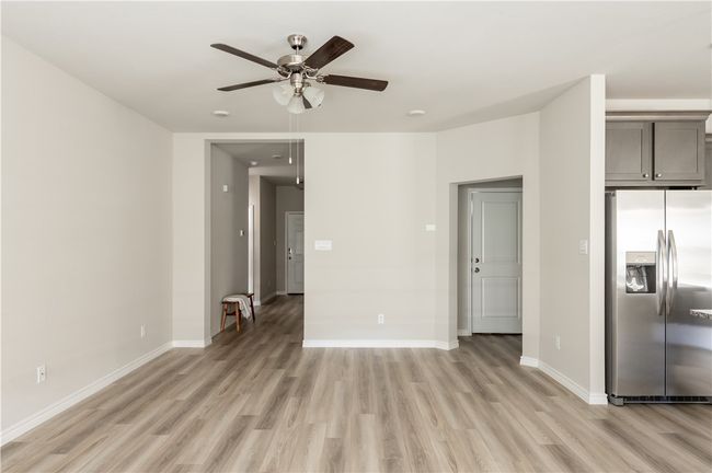 Unfurnished living room featuring baseboards, light wood-style flooring, and a ceiling fan | Image 8