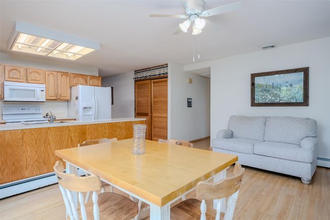 Dining area with wood finished floors and a baseboard radiator | Image 16