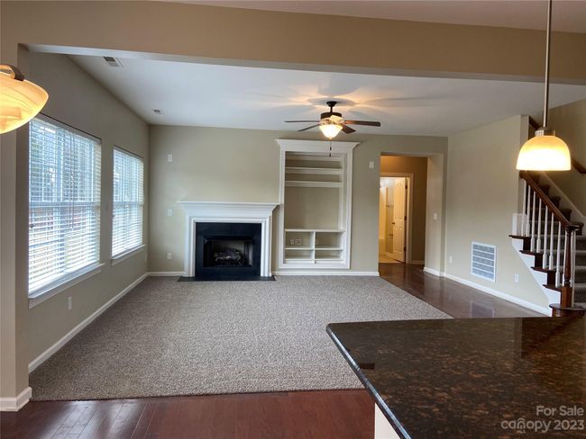 View of great room from breakfast. Hall to the back right corner leads to the main level bed, bath, and garage entry. | Image 11