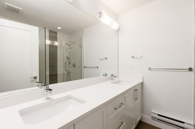 Full bath with baseboard heating, visible vents, a sink, and a stall shower | Image 19