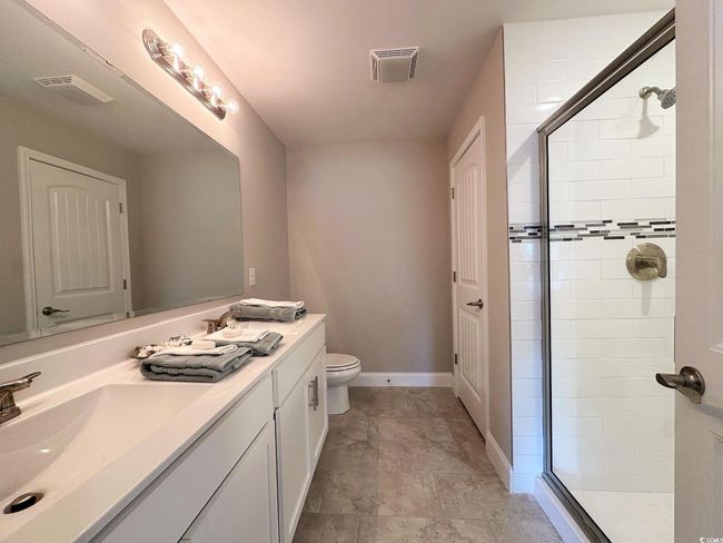 Bedroom with dark wood-type flooring, baseboards, vaulted ceiling, and visible vents | Image 12