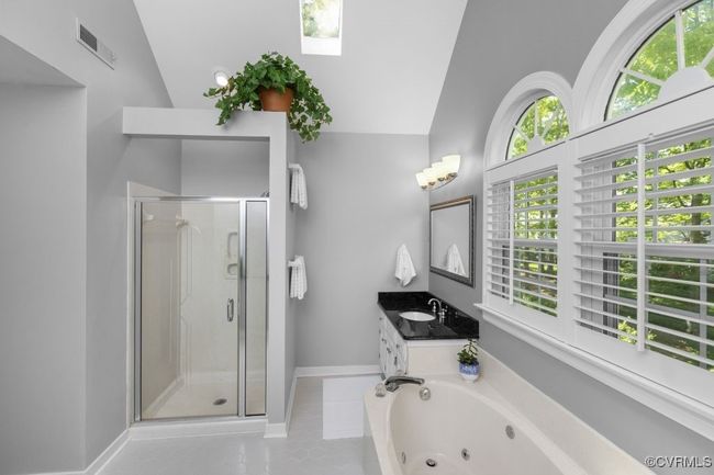 Full bathroom with a shower stall, vanity, a tub with jets, lofted ceiling, and tile patterned floors | Image 28