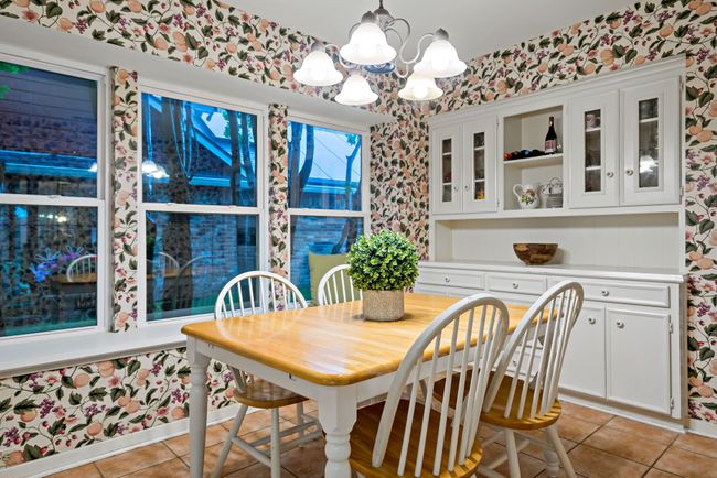 Dining area featuring a chandelier, light tile floors, and built-ins | Image 15