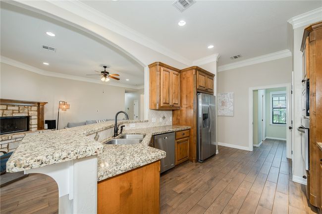 Kitchen featuring visible vents, a peninsula, appliances with stainless steel finishes, and a sink | Image 9