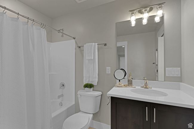 Bathroom featuring vanity and shower / bath combination with curtain | Image 11