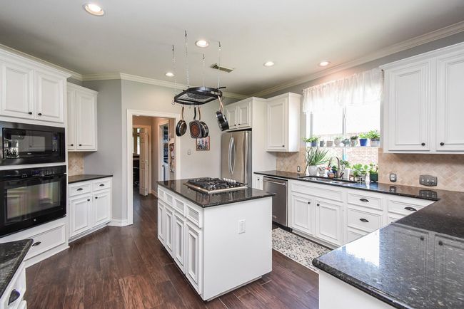 You will love cooking in this kitchen with a spacious island and built-in cooktop, this bright and airy space is filled with natural light from surrounding windows—creating the perfect setting for culinary creativity and conversation. | Image 8