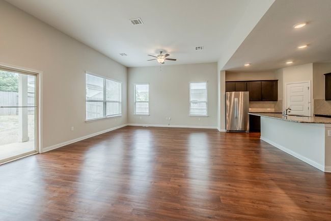 Unfurnished living room with visible vents, a ceiling fan, a healthy amount of sunlight, and recessed lighting | Image 4