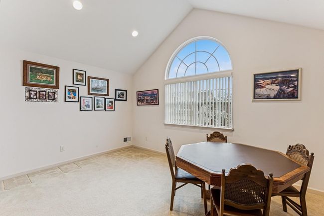 Dining room featuring baseboards, visible vents, vaulted ceiling, and light colored carpet | Image 19