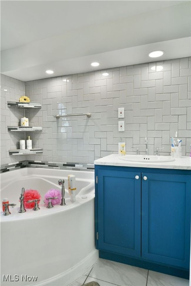 Full bathroom featuring marble finish floor, recessed lighting, vanity, and a bath | Image 30