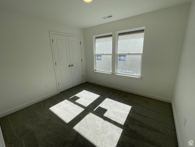 Unfurnished bedroom featuring dark carpet and a closet | Image 14