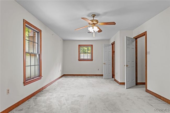 Unfurnished bedroom with light colored carpet and ceiling fan | Image 18