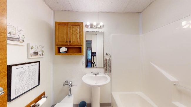 Bathroom with a paneled ceiling, a chandelier, a sink, and shower / bathtub combination | Image 12