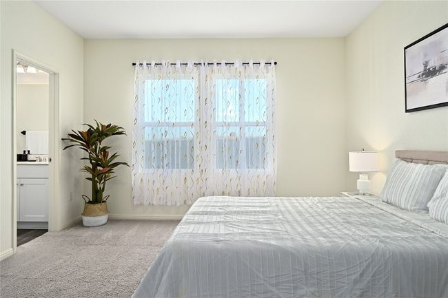 Carpeted bedroom featuring baseboards and connected bathroom | Image 24