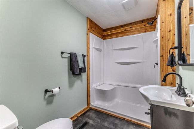 Bathroom with toilet, a shower stall, vanity, wood finished floors, and baseboards | Image 36