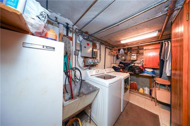 Laundry area featuring electric panel, washer and clothes dryer, and tile patterned floors | Image 28