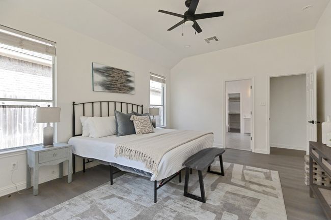 Bedroom featuring wood finished floors, lofted ceiling, a ceiling fan, and a spacious closet | Image 15