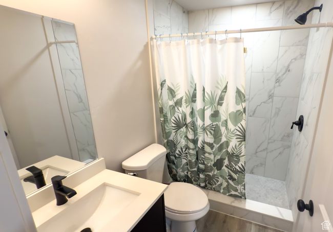 Full bath featuring a shower with shower curtain, vanity, and wood finished floors | Image 23