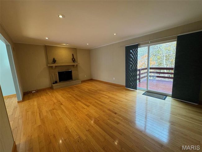 family room featuring a fireplace, light hardwood / wood-style flooring, and crown molding | Image 16