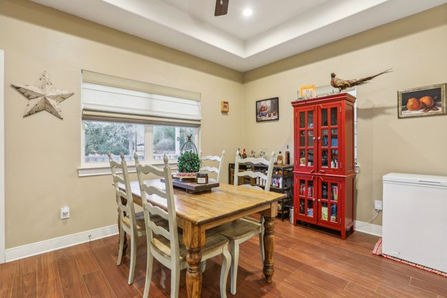 Dining space featuring hardwood / wood-style flooring, ceiling fan, and a raised ceiling | Image 13