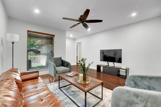 Unit 7338- Living area with a ceiling fan, wood finished floors, and recessed lighting | Image 6