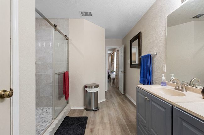 Full bath with a shower stall, visible vents, and wood finished floors | Image 26