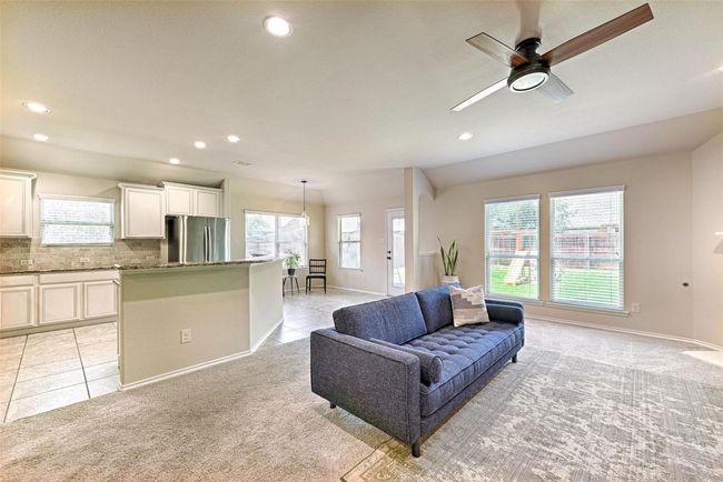 Living room featuring light carpet, plenty of natural light, ceiling fan, recessed lighting, and light tile patterned floors | Image 7