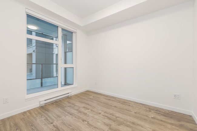 Unfurnished room featuring baseboard heating, wood finished floors, and baseboards | Image 12