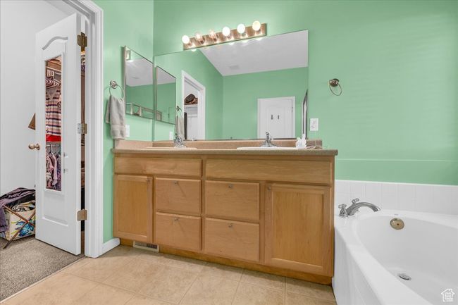 Full bath with tile patterned flooring, a bath, double vanity, and a sink | Image 21