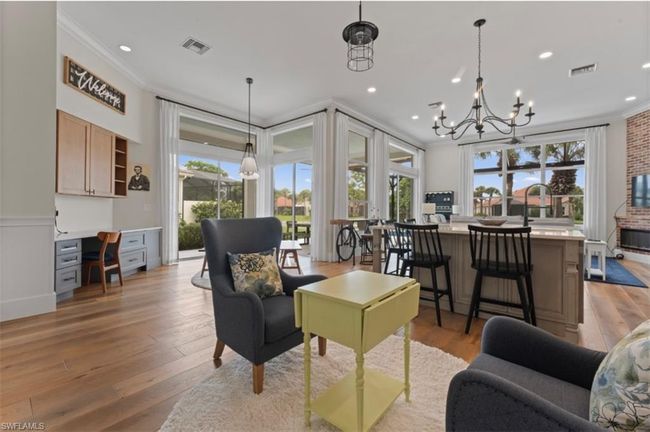 Living area featuring crown molding, light wood-style floors, a chandelier, recessed lighting, and a wainscoted wall | Image 8