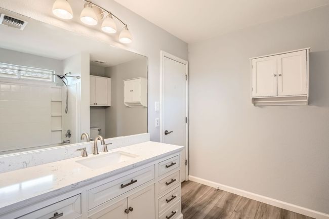 Bathroom featuring baseboards, toilet, visible vents, vanity, and wood finished floors | Image 15