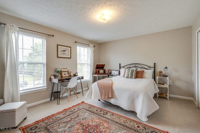 Bedroom with carpet flooring, a textured ceiling, and a desk | Image 28