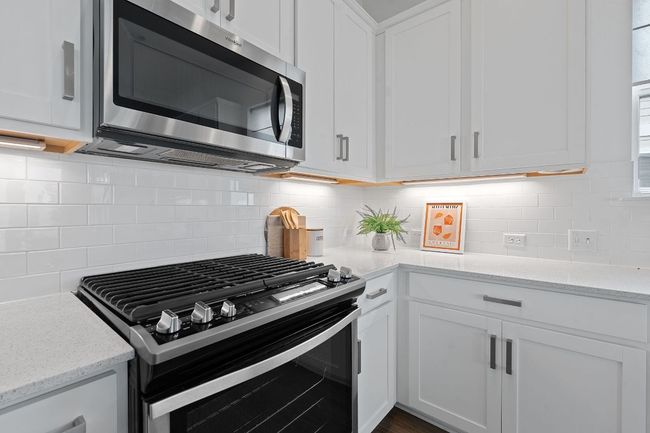 Desirable modern finishes include sleek quartz countertops, stainless steel appliances, and classic subway tile backsplash. | Image 15