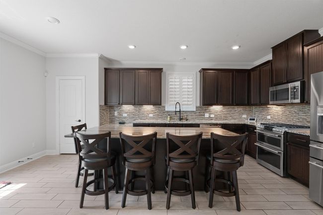 Kitchen with an extended breakfast bar and pantry closet | Image 12