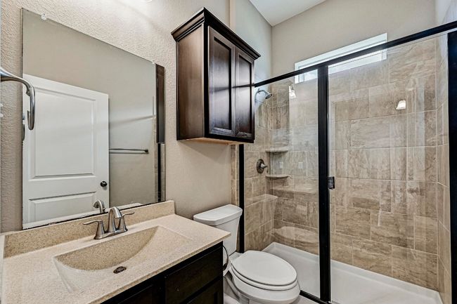 Full bathroom featuring a shower stall, vanity, and a textured wall | Image 21