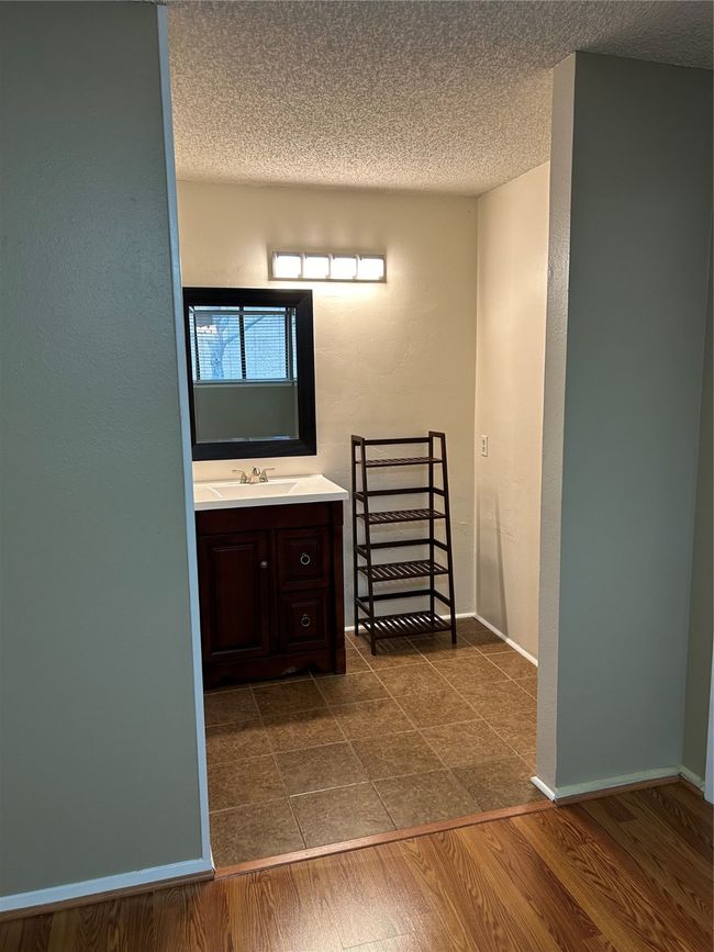 Bathroom featuring a textured ceiling, wood-type flooring, and vanity | Image 23
