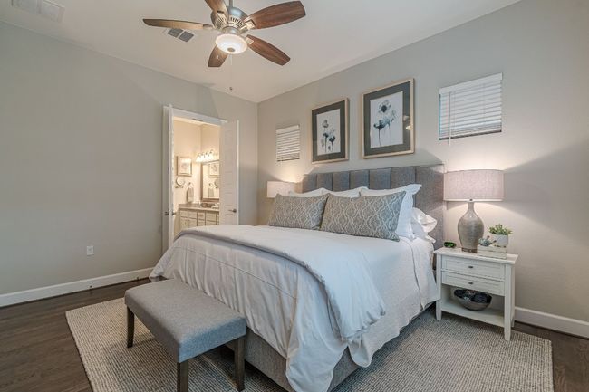 Bedroom with baseboards, wood finished floors, ensuite bathroom, and a ceiling fan | Image 28