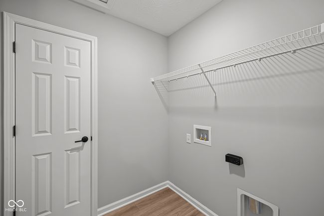 laundry area with baseboards, light wood-style flooring, laundry area, and hookup for a washing machine | Image 14